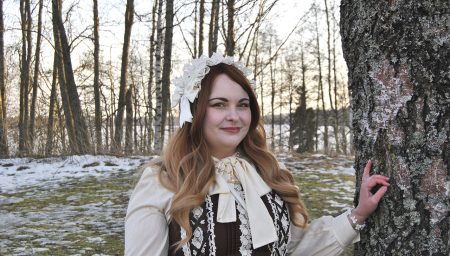 Nainen keväisessä koivumetsässä.