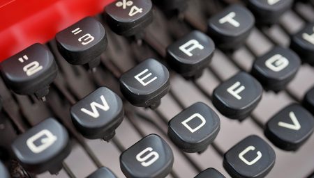 Kirjoituskoneen näppäimistöä osittain näkyvillä.