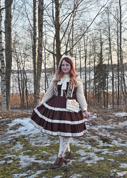 Nainen keväisessä koivumetsässä.